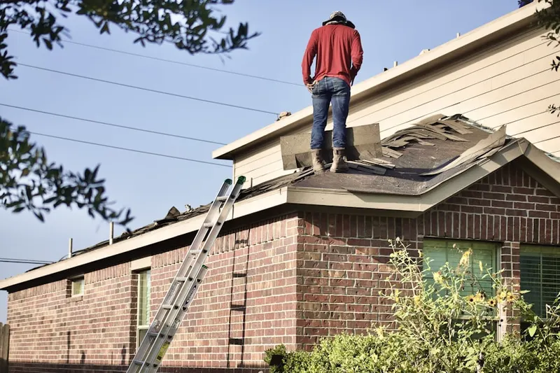 Professional roofer working on a residential roof in Alpena